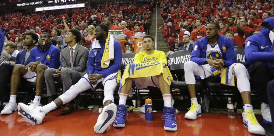 Caras largas se observan en el banco de los Warriors, quienes fueron derrotados anoche por los Rockets de Houston. (AP) (horizontal-x3)