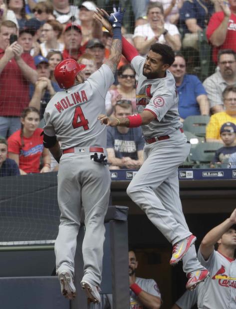 El puertorriqueño Yadier Molina, de los Cardenales de San Luis, celebra su jonrón de dos carreras con su compañero, el venezolano José Martinez, durante el sexto inning de un juego de béisbol contra los Cerveceros de Milwaukee, el sábado 23 de junio de 20 (vertical-x1)