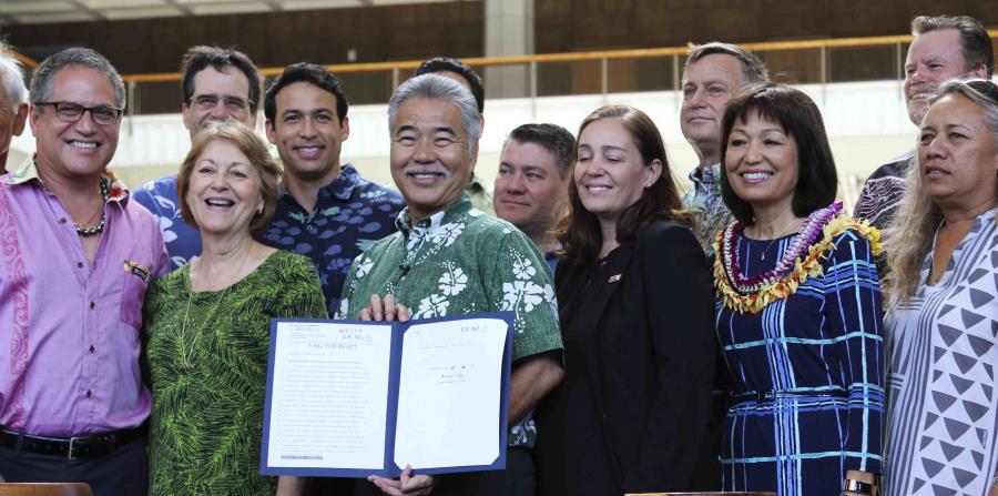 El gobernador de Hawái, David Ige (centro), junto a legisladores, muestra la medida, que firmó en Honolulu el martes. (AP) (horizontal-x3)
