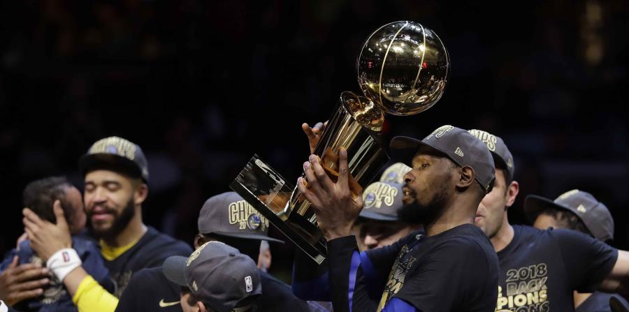 El delantero y Jugador Más Valioso de la serie final, Kevin Durant, levanta el trofeo Larry O'Brien luego que los Warriors de Golden State completaron la barrida de los Cavaliers de Cleveland. (AP / Tony Dejak) (horizontal-x3)