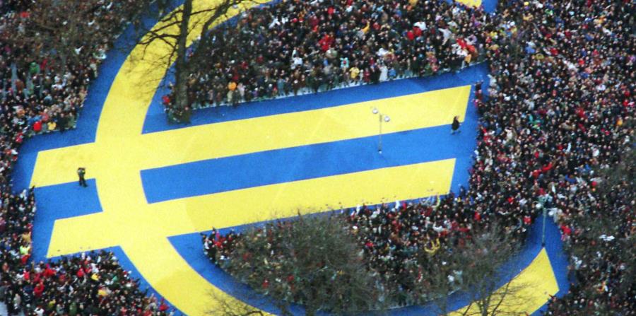 Miles de personas rodean un enorme símbolo del euro en un parque de Fráncfort. (horizontal-x3)
