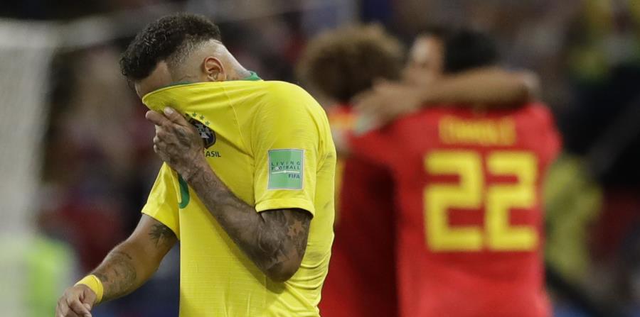 Neymar, de la selección de Brasil, se cubre el rostro con la camiseta mientras los jugadores de Bélgica festejan su triunfo en los cuartos de final de la Copa del Mundo. (AP) (horizontal-x3)