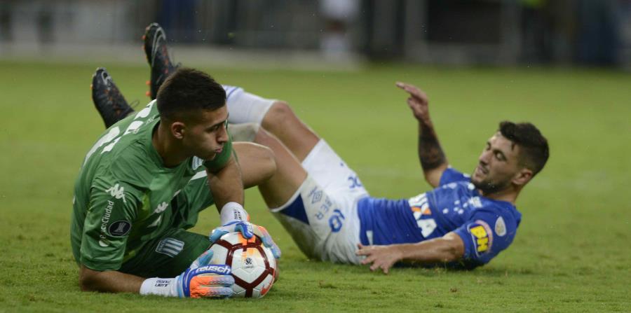 Giorgian de Arrascaeta (der.) observa cómo el arquero de Racing Juan Musso atrapa el balón. (horizontal-x3)