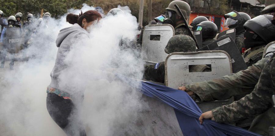 Seguidores del candidato opositor a la presidencia de Honduras, Salvador Nasralla, se enfrentan a la policía militar por una bandera gigante del país (horizontal-x3)