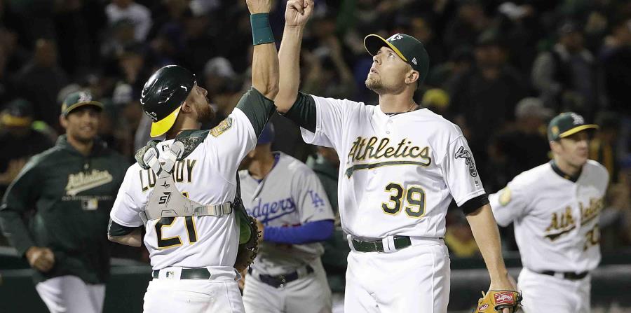 El receptor Jonathan Lucroy y el pitcher Blake Treinen celebran la victoria. (AP) (horizontal-x3)