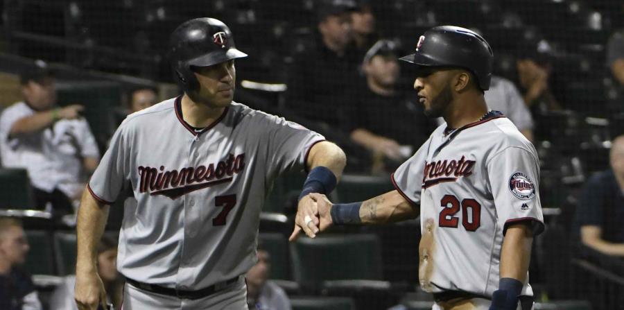 Joe Mauer y Eddie Rosario se felicitan después de anotar en la novena entrada. (AP) (horizontal-x3)