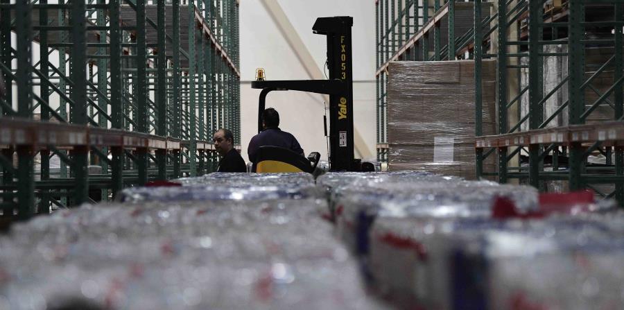 Empleados de FEMA moviendo cajas de agua en el centro de distribución de la agencia (horizontal-x3)