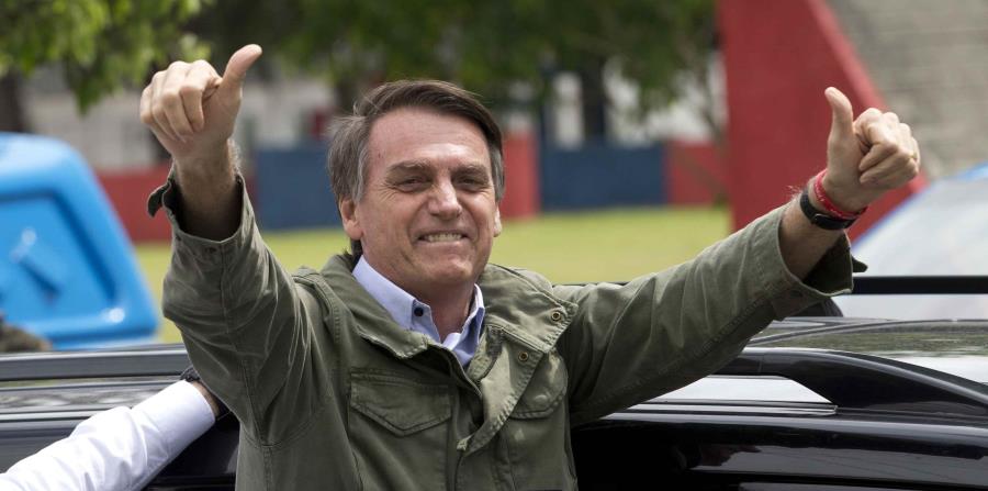 Jair Bolsonaro saluda al público luego de ejercer su voto en la segunda vuelta de las elecciones presidenciales en Brasil. (AP / Silvia Izquierdo) (horizontal-x3)