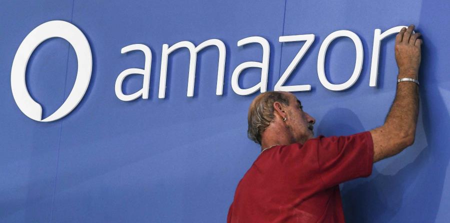 Un trabajador ajusta el logo de Amazon. (EFE) (horizontal-x3)