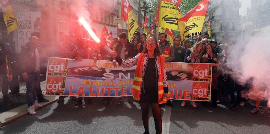 Una persona sostiene una luz de bengala en su mano mientras participa en la manifestación contra la reforma laboral en Francia. (horizontal-x3)