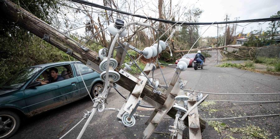 Un conductor pasa debajo de un poste caído en una calle de Mayagüez poco después del paso del huracán María. (GFR Media) (horizontal-x3)