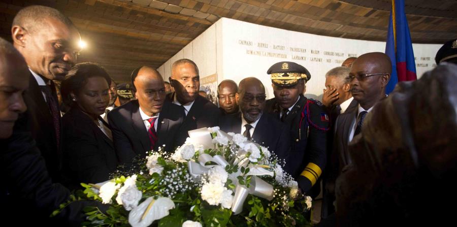 El presidente haitiano Jovenel Moïse, cuarto de izquierda a derecha, coloca flores frente a un monumento durante una ceremonia por el 215to aniversario de la Batalla de Vertieres. (AP / Dieu Nalio Chery) (horizontal-x3)