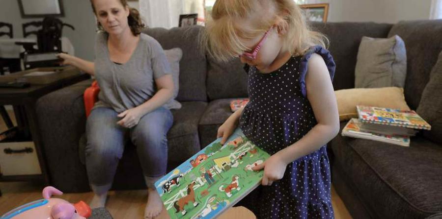 En fotografía del lunes 23 de julio de 2018, Brooke Adams, de cinco años, juega con sus juguetes frente a su madre Jana momentos antes de sufrir un ataque de epilepsia en su hogar en Santa Rosa, California (horizontal-x3)