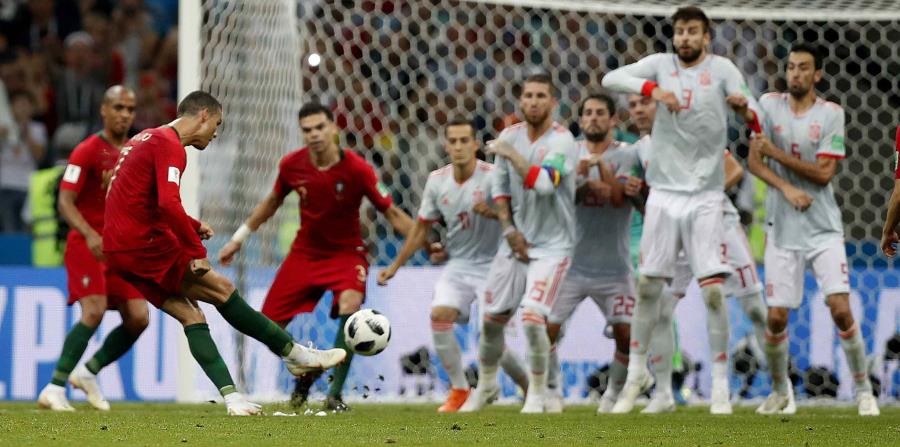 Cristiano Ronaldo ejecutó exquisitamente un tiro libre con el que completó su triplete en el empate de Portugal ante España. (AP) (horizontal-x3)