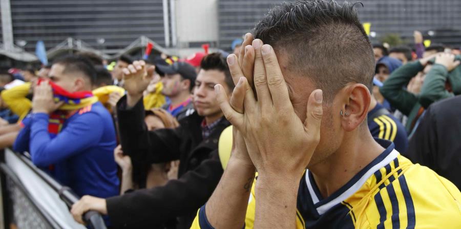 Un aficionado de Colombia se cubre el rostro durante la transmisión del partido entre esa selección sudamericana e Inglaterra en el Mundial de Rusia, en Bogotá. (AP) (horizontal-x3)