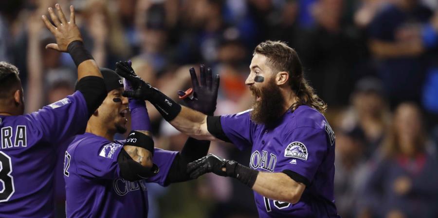 Gerardo Parra (izquierda), Carlos González y Charlie Blackmon celebran el cuadrangular. (AP) (horizontal-x3)