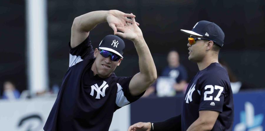 Aaron Judge, izquierda, y Giancarlo Stanton, ambos de los Yanquis de Nueva York, practican estiramientos en un campamento de entrenamientos de primavera (horizontal-x3)