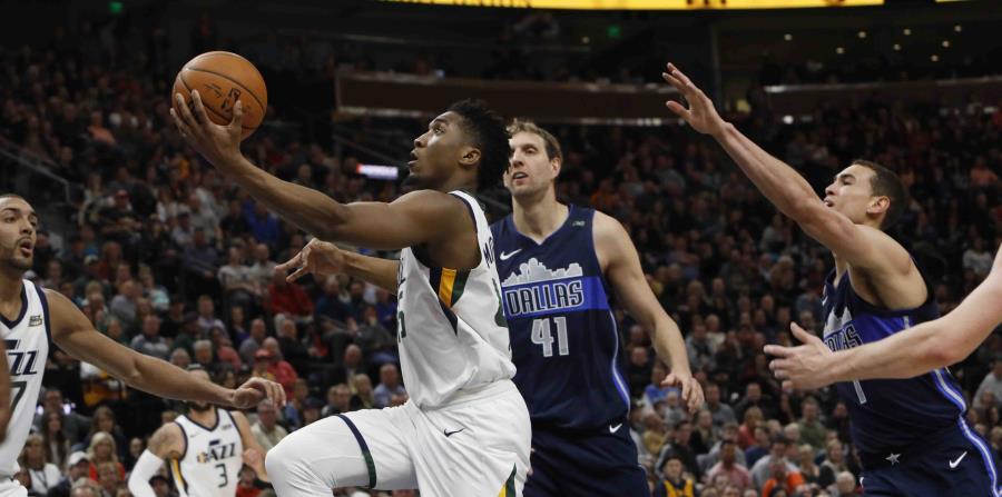 El jugador del Jazz de Utah Donovan Mitchell, en el centro, ataca el aro en el partido. (horizontal-x3)