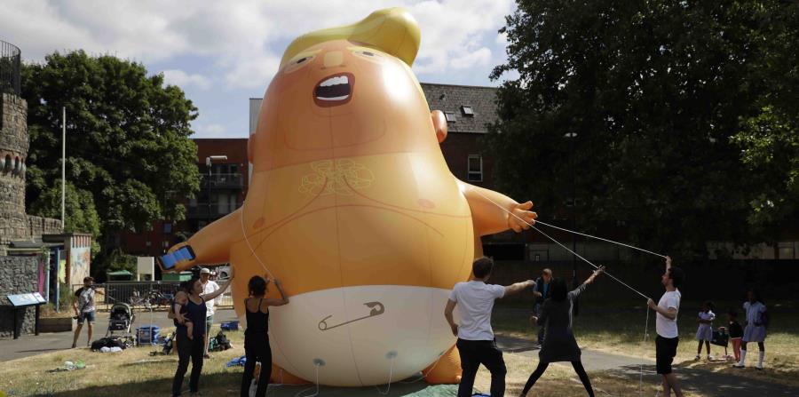 un globo de seis metros de altura que representa al presidente estadounidense Donald Trump es levantado durante una sesión de pruebas en Bingfield Park, Londres. (AP (horizontal-x3)