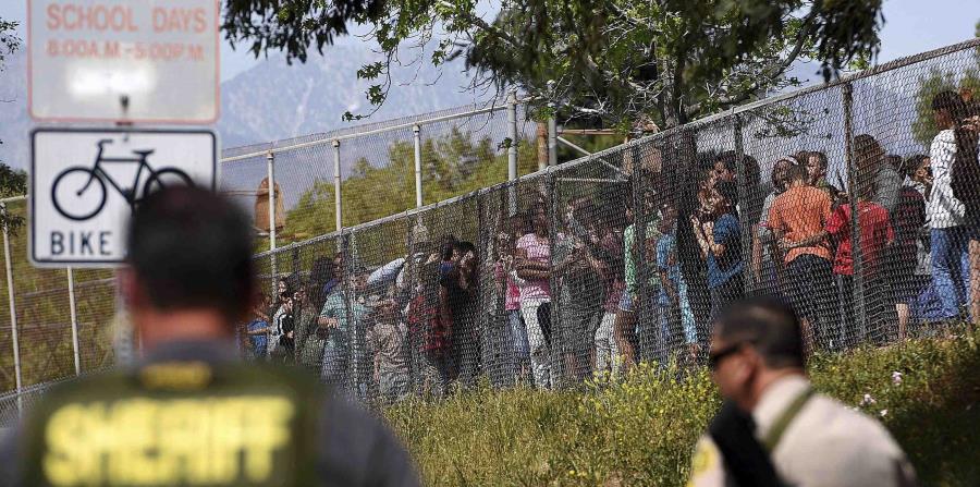 Estudiantes de la escuela elemental North Park, en San Bernardino, detrás de una verja luego de un tiroteo. (GFR Media) (horizontal-x3)