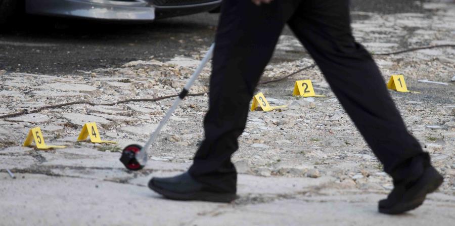 Un agente de la Policía toma medidas en la escena de un asesinato. (GFR Media) (horizontal-x3)