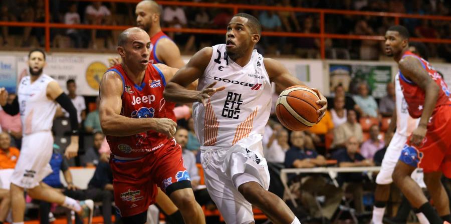 Gary Browne, de los Atléticos, maneja el balón contra el veterano Carlos Arroyo. (horizontal-x3)