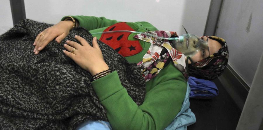 En esta imagen difundida por la agencia noticiosa oficial siria SANA, se ve a una mujer recibiendo oxígeno a través de una mascarilla después de un supuesto ataque químico en su localidad de al-Khalidiya, en Alepo, Siria, el sábado 25 de noviembre de 2018 (horizontal-x3)