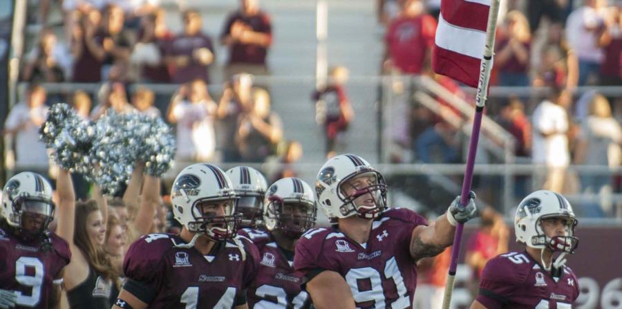 En esta fotografía del 18 de septiembre de 2010, proporcionada por la Universidad del Sur de Illinois, Jason Seaman sostiene la bandera estadounidense en un partido de fútbol americano en Carbondale, Illinois. Seaman (horizontal-x3)