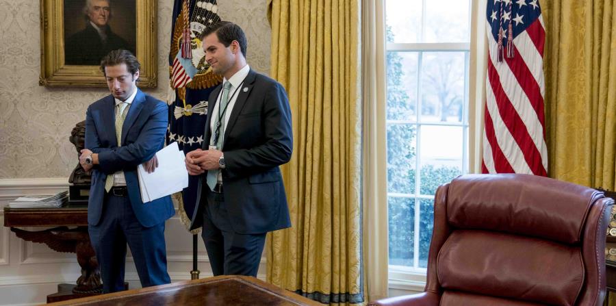 El asistente personal del presidente Donald Trump, John McEntee (der) en la Oficina Oval junto con Eli Miller, asistente del secretario del tesoro Steve Mnuchin el 31 de enero del 2018. (AP) (horizontal-x3)