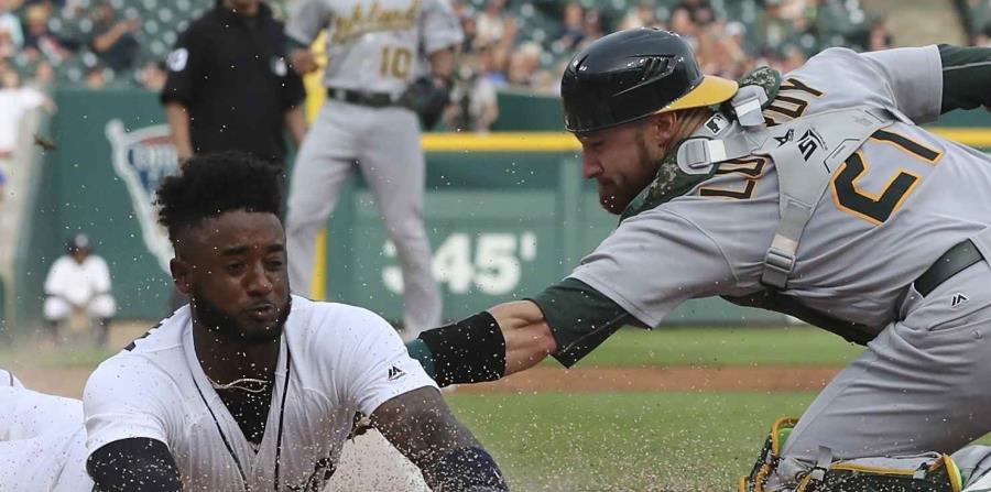 En esta foto del 26 de junio de 2018, Jonathan Lucroy (der.) saca en el plato a Niko Goodrum, de los Tigres de Detroit. (AP / Carlos Osorio) (horizontal-x3)