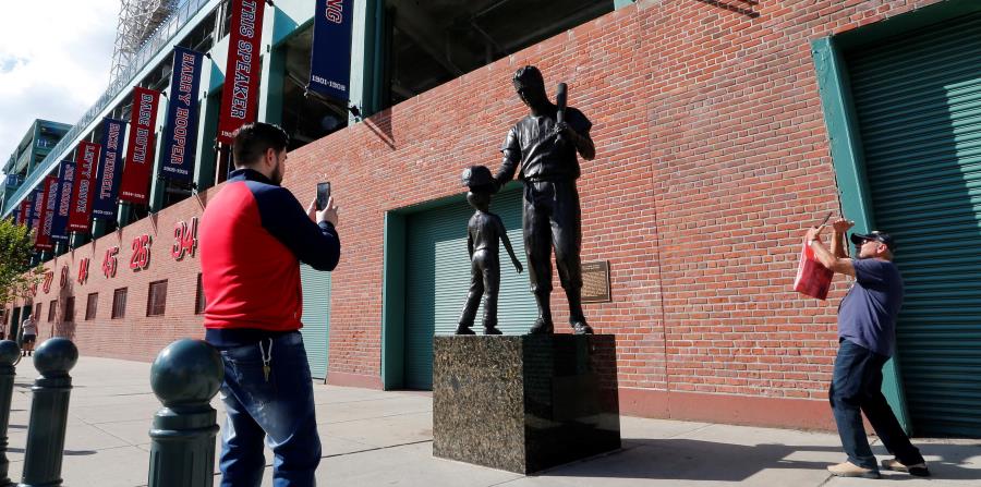 Dos fanáticos de los Medias Rojas se detienen en los alrededores del Fenway Park para retratar la estatua del legendario Ted Williams, cuando la novena local abrirá mañana la Serie de Campeonato de la Liga Americana ante Houston. (AP / Elise Amendola) (horizontal-x3)
