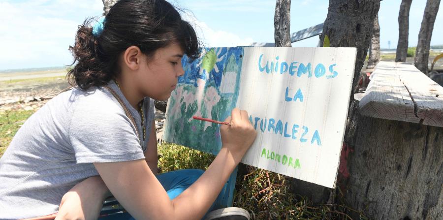 Alondra Caraballo Rodríguez disfruta de pintar rótulos en la Playa de Guayanilla, con mensajes de concienciación ambiental. (horizontal-x3)