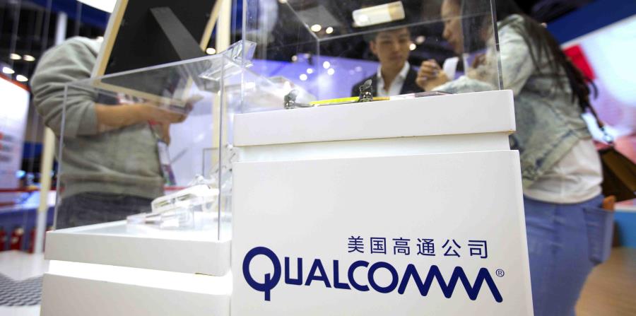 Algunos visitantes examinan la caseta de Qualcomm en la Conferencia Global de Internet Móvil, en Beijing. (horizontal-x3)