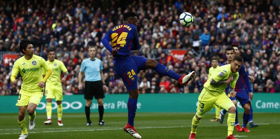 Yerry Mina, al centro, patea la bola en el partido contra el Getafe en el Camp Nou, en Barcelona. (AP) (horizontal-x3)