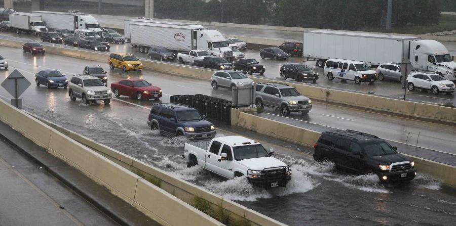 Los vehículos transitan por las inundaciones en una carretera de la ciudad de Houston. (AP) (horizontal-x3)