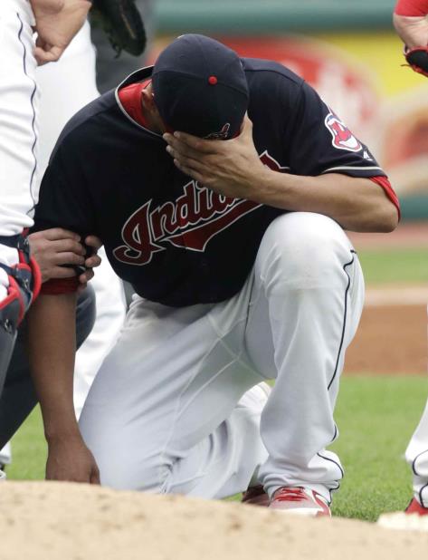 El abridor venezolano Carlos Carrasco, de los Indios de Cleveland, se duele tras recibir un pelotazo en el brazo derecho durante un batazo en el partido ante los Mellizos de Minnesota, el sábado 16 de junio de 2018, en Cleveland. (AP) (vertical-x1)