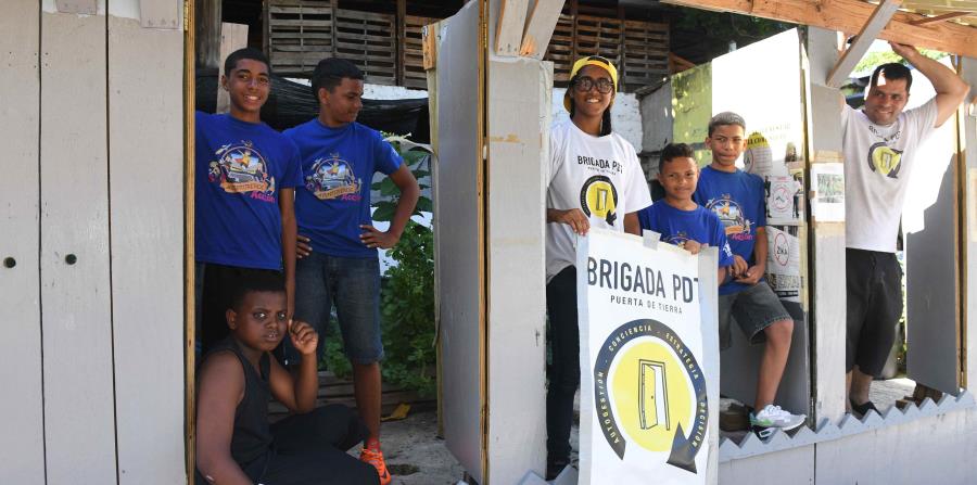 Jesús “Bubu” Negrón y los niños de Puerta de Tierra celebran la gesta de crear una parada de guagua que tiene por techo un árbol de almendro y que se ajusta a las necesidades de la comunidad. (horizontal-x3)