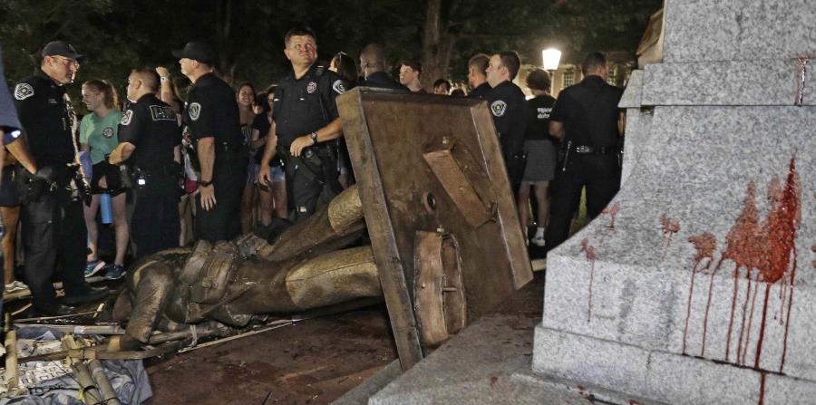 La Policía custodia la estatua derribada. (AP) (horizontal-x3)
