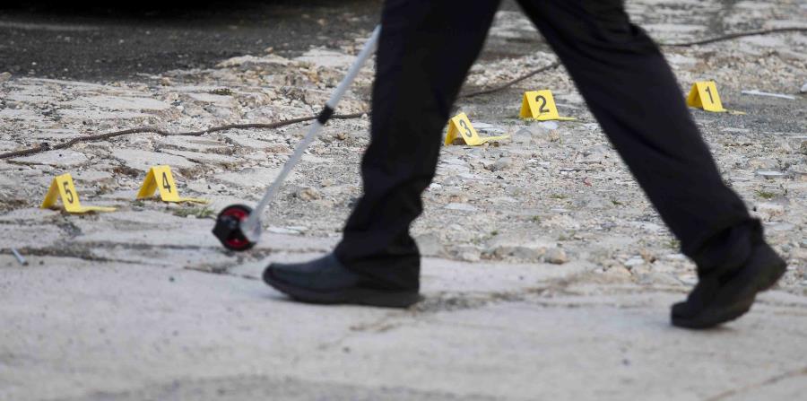 Un agente toma medidas en una escena de un asesinato. (GFR Media) (horizontal-x3)