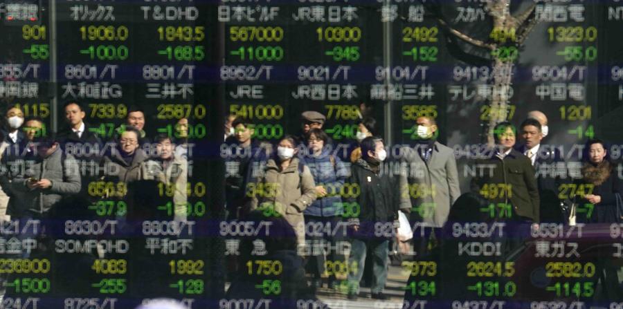 La imagen de varias personas se refleja en el indicador accionario electrónico de una firma de valores en Tokio (horizontal-x3)