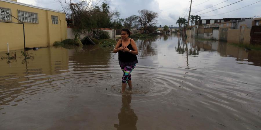 Una mujer camina por una de las calles que se inundaron tras el paso del huracán María en la urbanización Levittown, en Toa Baja. (GFR Media) (horizontal-x3)