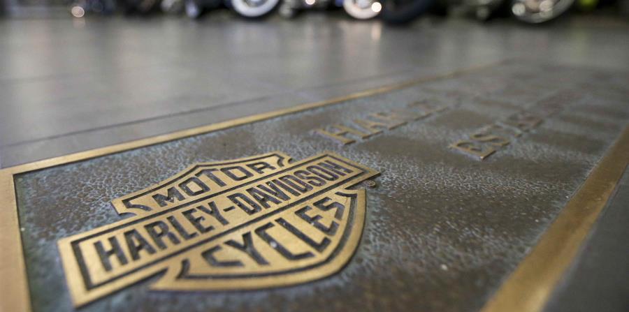 Varias motocicletas Harley-Davidson formadas detrás de un logotipo de la empresa en el piso de una sala de exhibición en Glenshaw, Pensilvania (horizontal-x3)