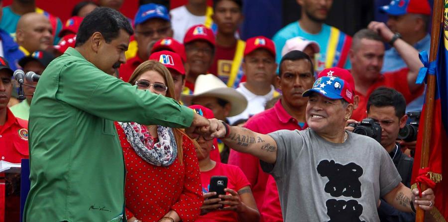 El presidente venezolano, Nicolás Maduro (i), saluda junto a la primera dama, Cilia Flores (c), y al exfutbolista argentino, Diego Maradona (d), durante su evento de cierre de campaña (horizontal-x3)