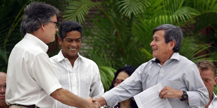 El jefe negociador del gobierno colombiano, Gustavo Bell (izq.), estrecha la mano del comandante del ELN Israel Ramírez Pineda (der.), alias Pablo Beltrán. (EFE / Ernesto Mastrascusa) (horizontal-x3)