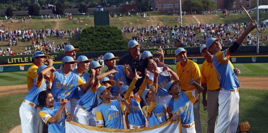 Mana Lau Kong (derecha), del equipo de Honolulu, se toma una selfie con sus compañeros luego de conquistar la Serie Mundial de Pequeñas Ligas. (AP) (horizontal-x3)