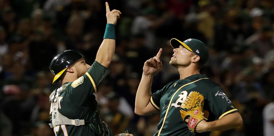 Jonathan Lucroy, receptor de los Atléticos, celebra con el taponero Blake Treinen luego de una victoria sobre Detroit. (horizontal-x3)
