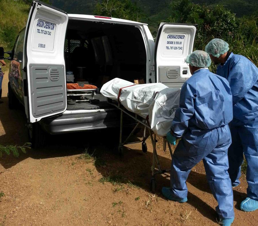 Personal del Negociado de Ciencias Forense introduce un cadáver en uno de sus vehículos. (GFR Media) (semisquare-x3)