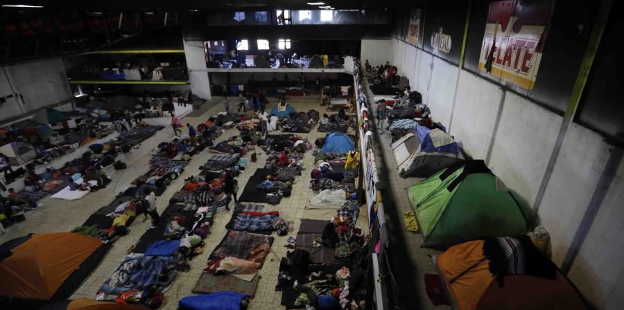 Migrantes descansan en una sala de conciertos que está siendo utilizada como albergue en Tijuana, México. (AP / Rebecca Blackwell) (horizontal-x3)