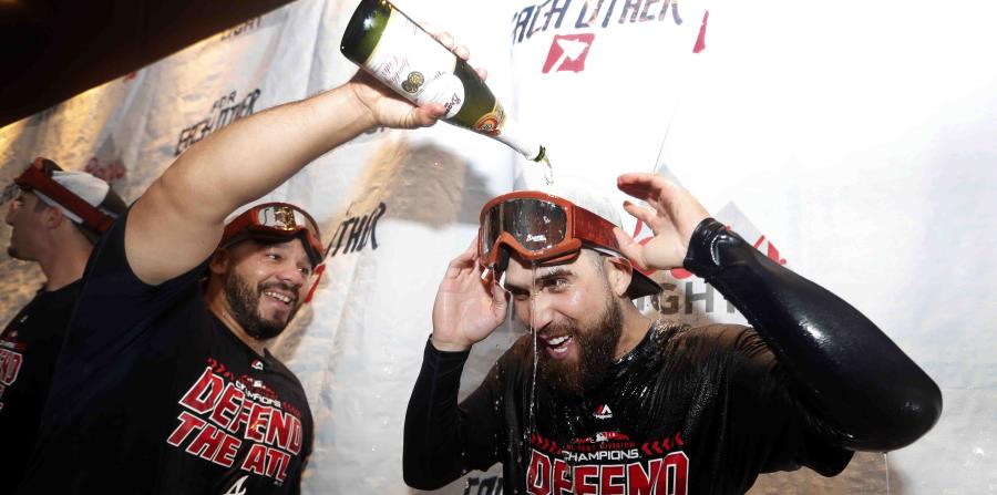 El receptor boricua René Rivera (izq.) derrama champaña sobre su compañero de equipo Ender Inciarte luego de capturar el banderín de la División del Este de la Liga Nacional. (AP / John Bazemore) (horizontal-x3)