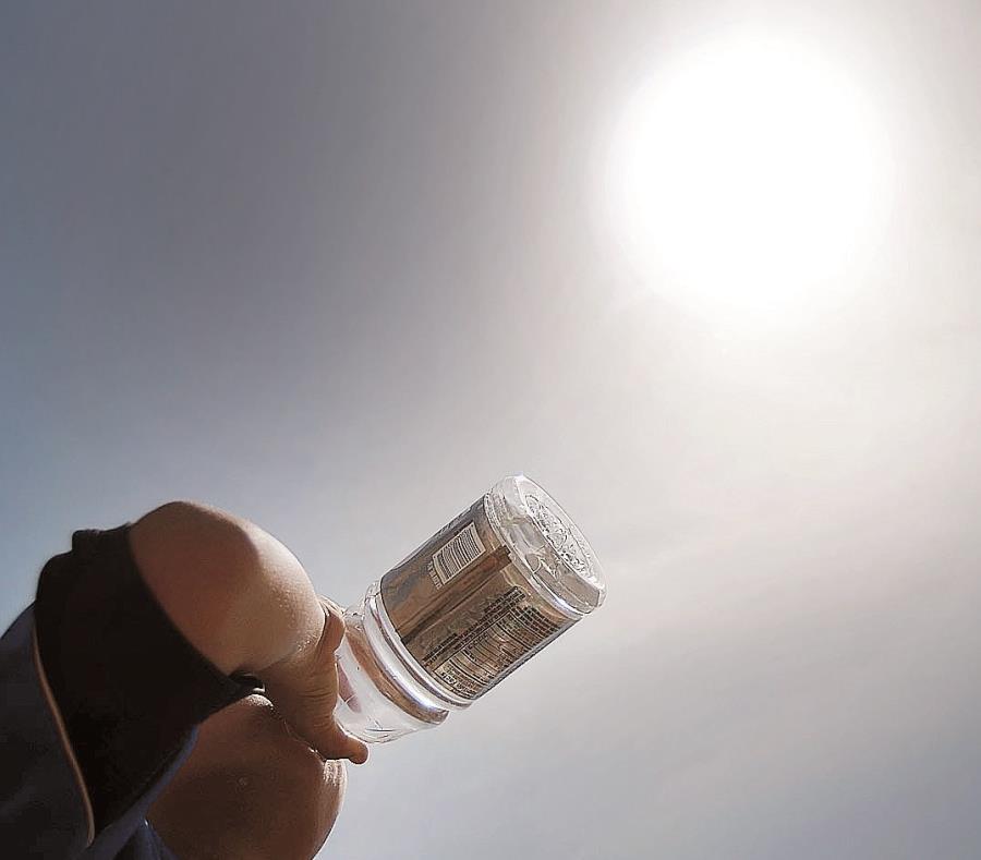 Un hombre bebe agua para aliviar el calor del día. (GFR Media) (semisquare-x3)